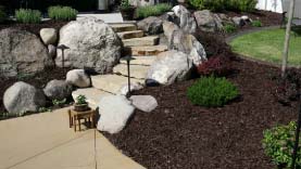 landscaped walkway with decorative bark mulch
